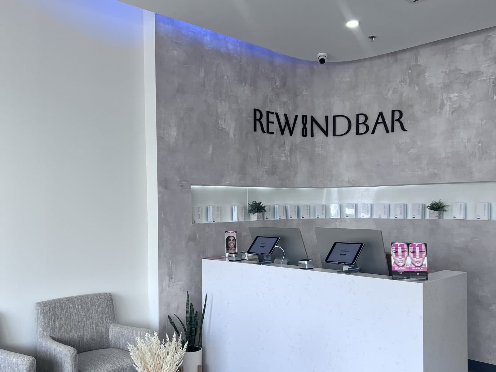 The reception desk and Rewind Bar wordmark wall inside the South Plainfield clinic