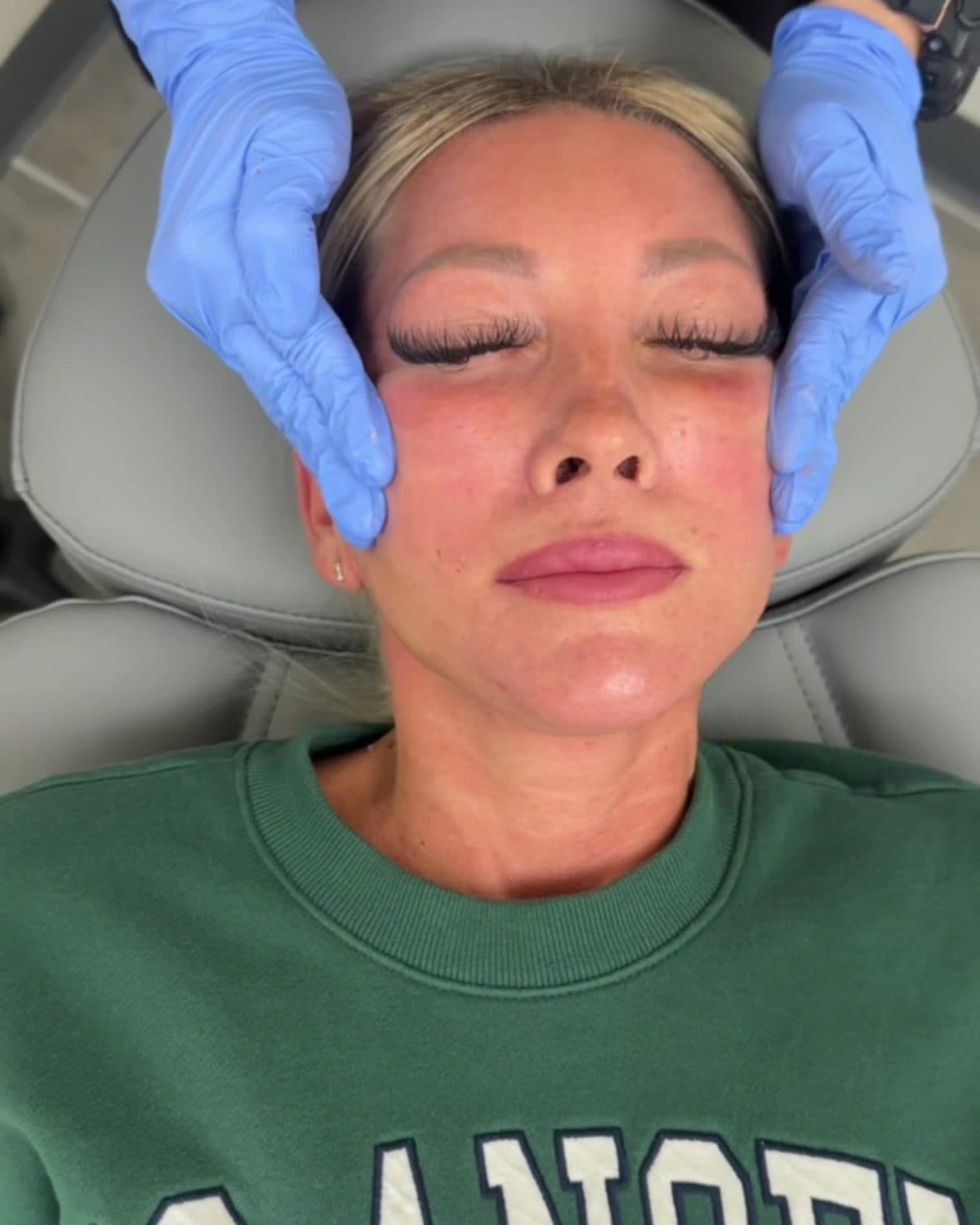A Rewind Bar aesthetician’s gloved hands on a client’s face during a facial